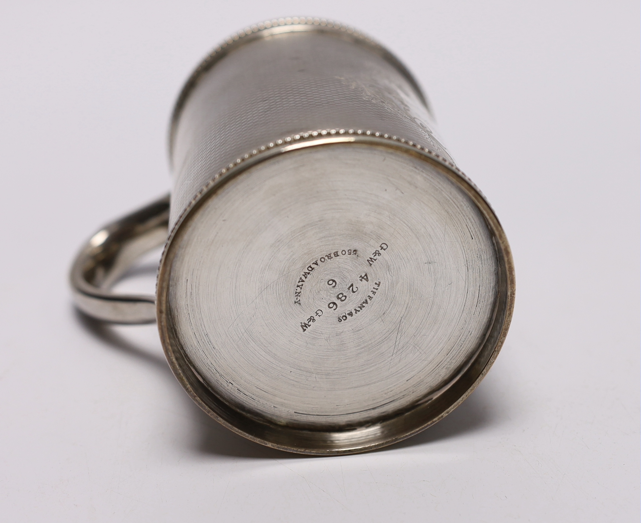 A mid 19th century Tiffany & Co (Grosjean & Woodward) engine turned sterling mug, with engraved inscription, 97mm, 6.9oz.